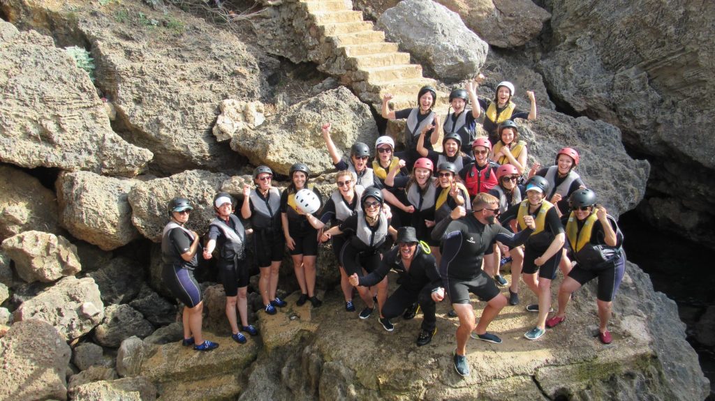 Photo de groupe du voyage Incentive à Palma au bord de la mer et des rochers.