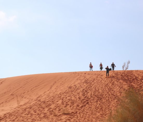 Quatre personnes au sommet d'une dune de sable en Jordanie