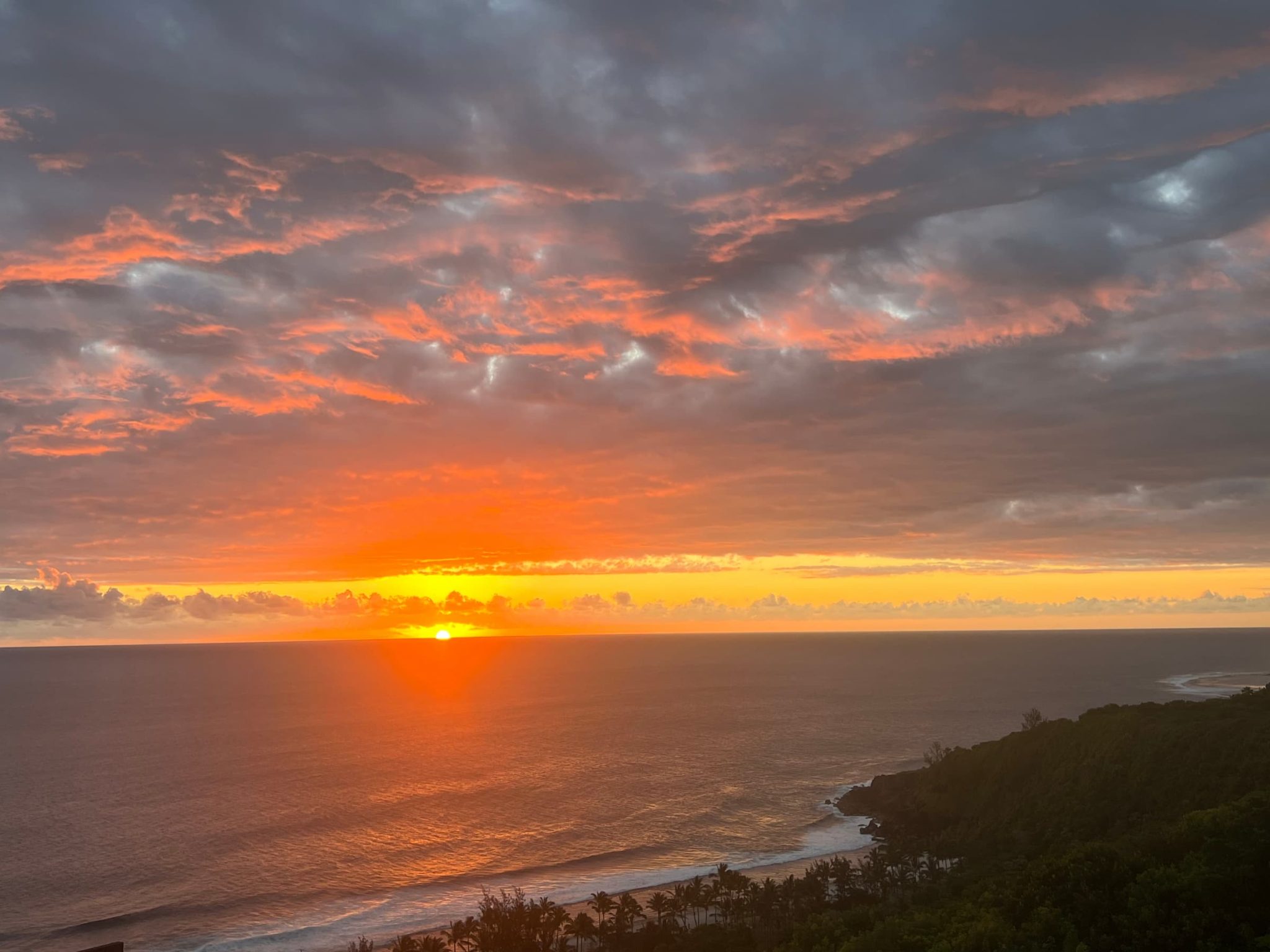 Voyage incentive à la Réunion. Vue sur un coucher de soleil avec l'océan Indien, la plage et la forêt.